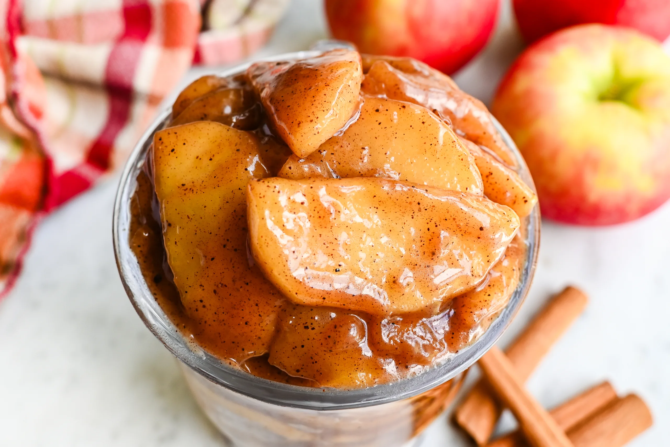 Close-up of thick apple pie filling with cinnamon and tender apple slices in a glass jar.