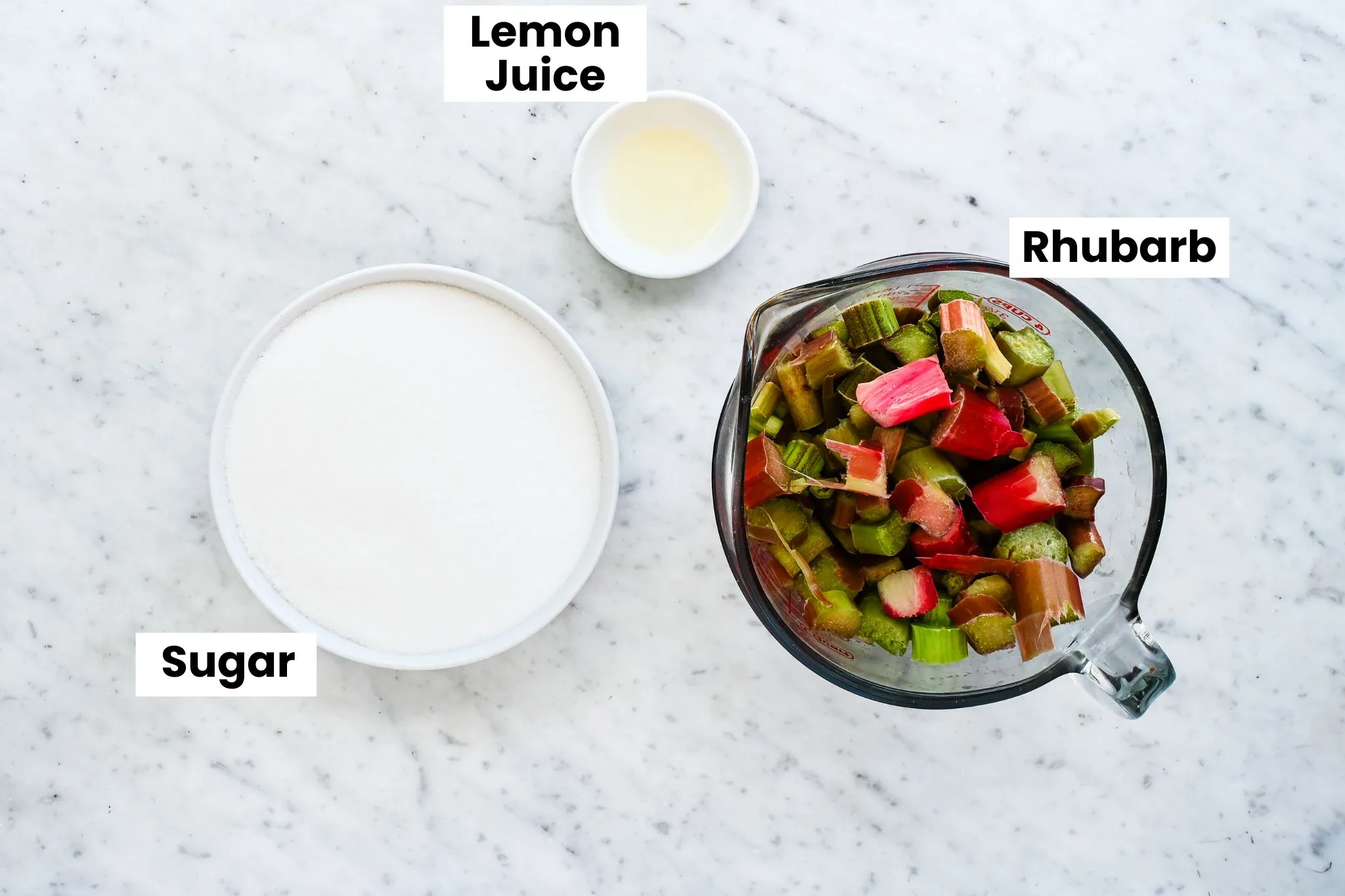 Ingredients for rhubarb jam with chopped rhubarb, sugar, and lemon juice.