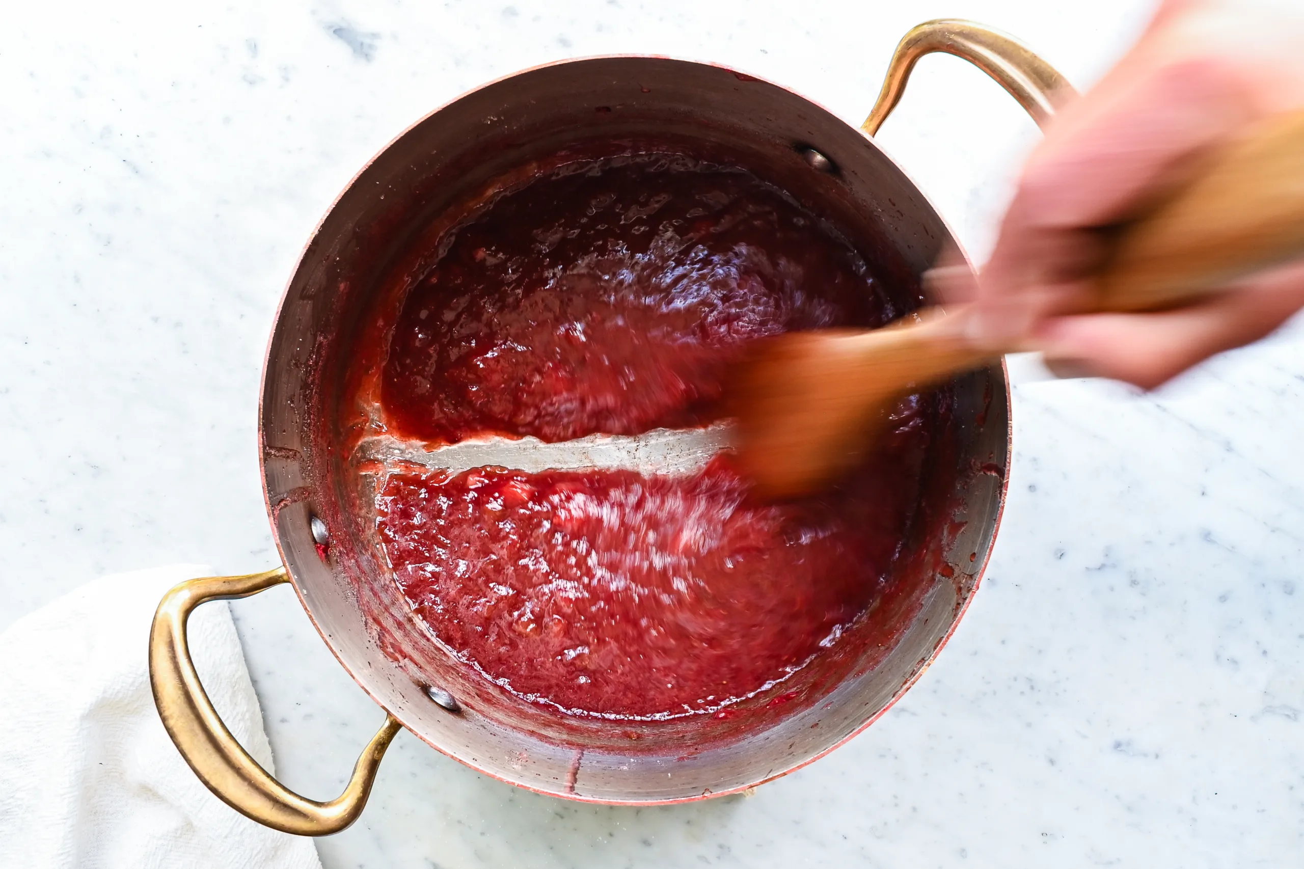 Strawberry rhubarb jam is ready when a wooden spoon scraped across the bottom of the pan leaves a clear path.