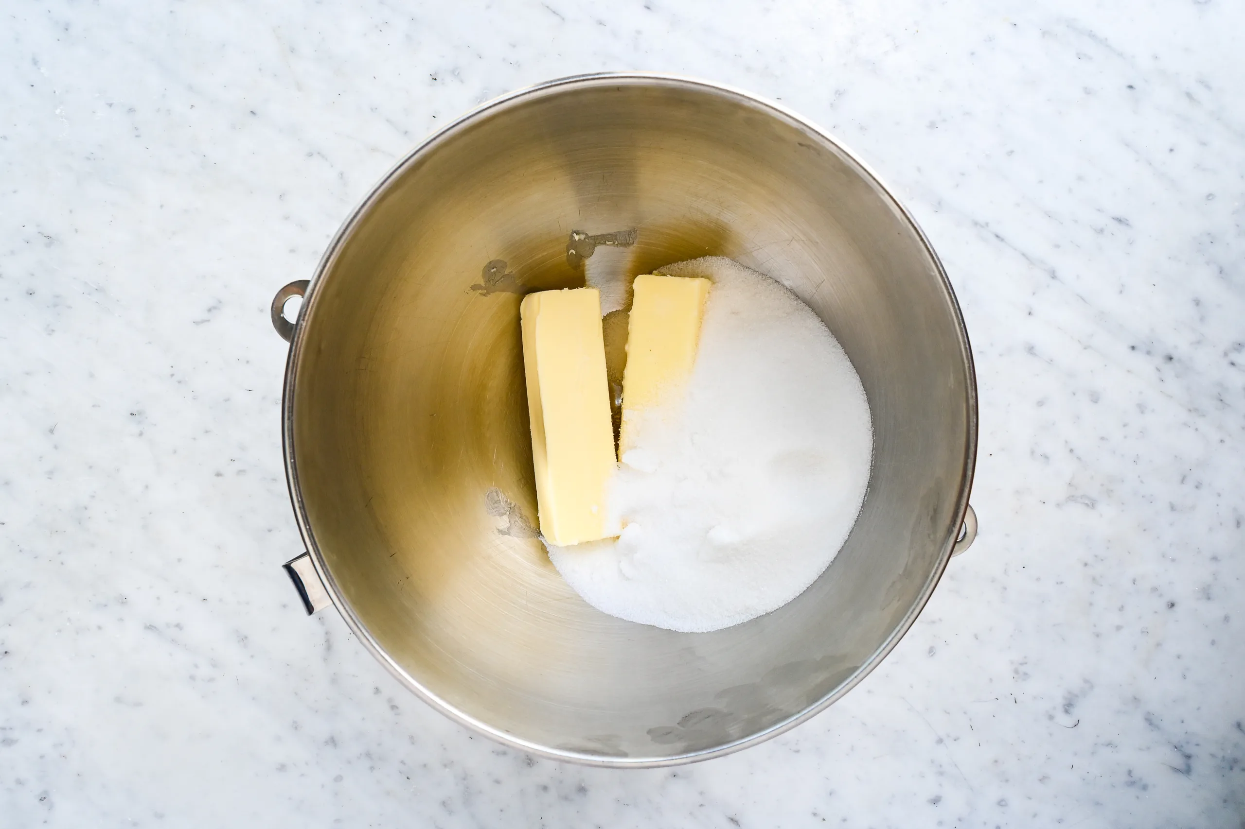 Butter and sugar in a stand mixer bowl for pumpkin bars.