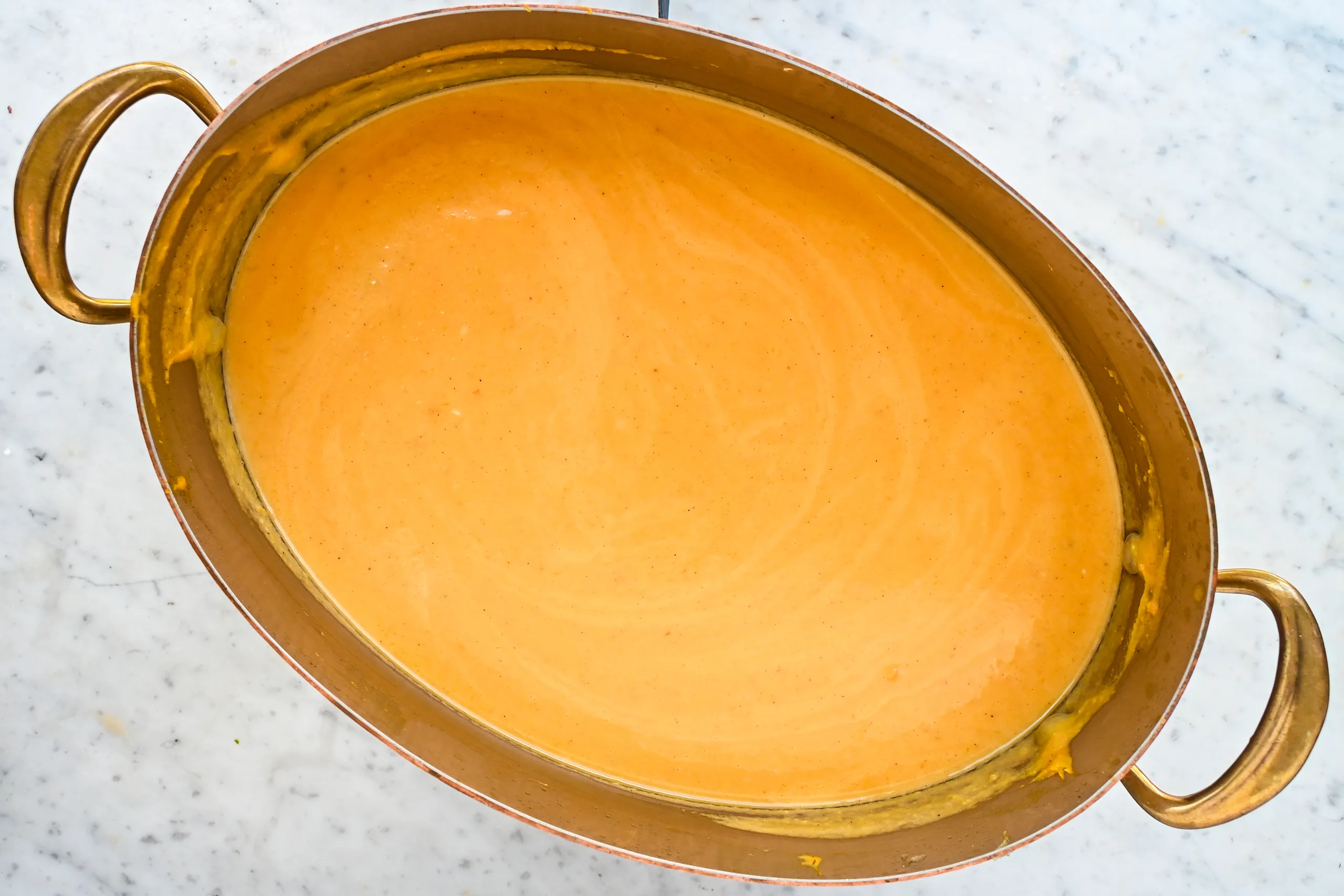 Smooth butternut pumpkin sweet potato soup in a copper pot.
