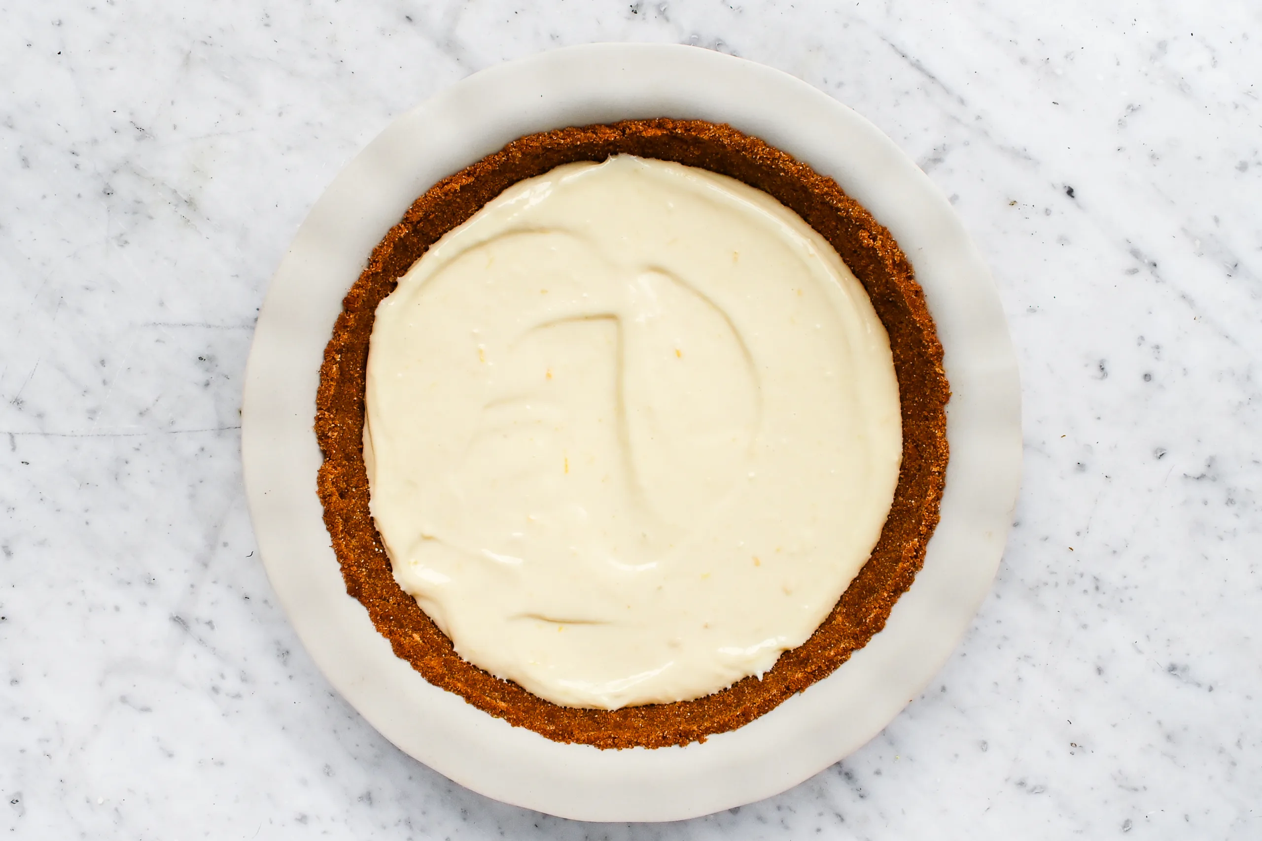 Lemon icebox pie filling spread into a graham cracker crust.