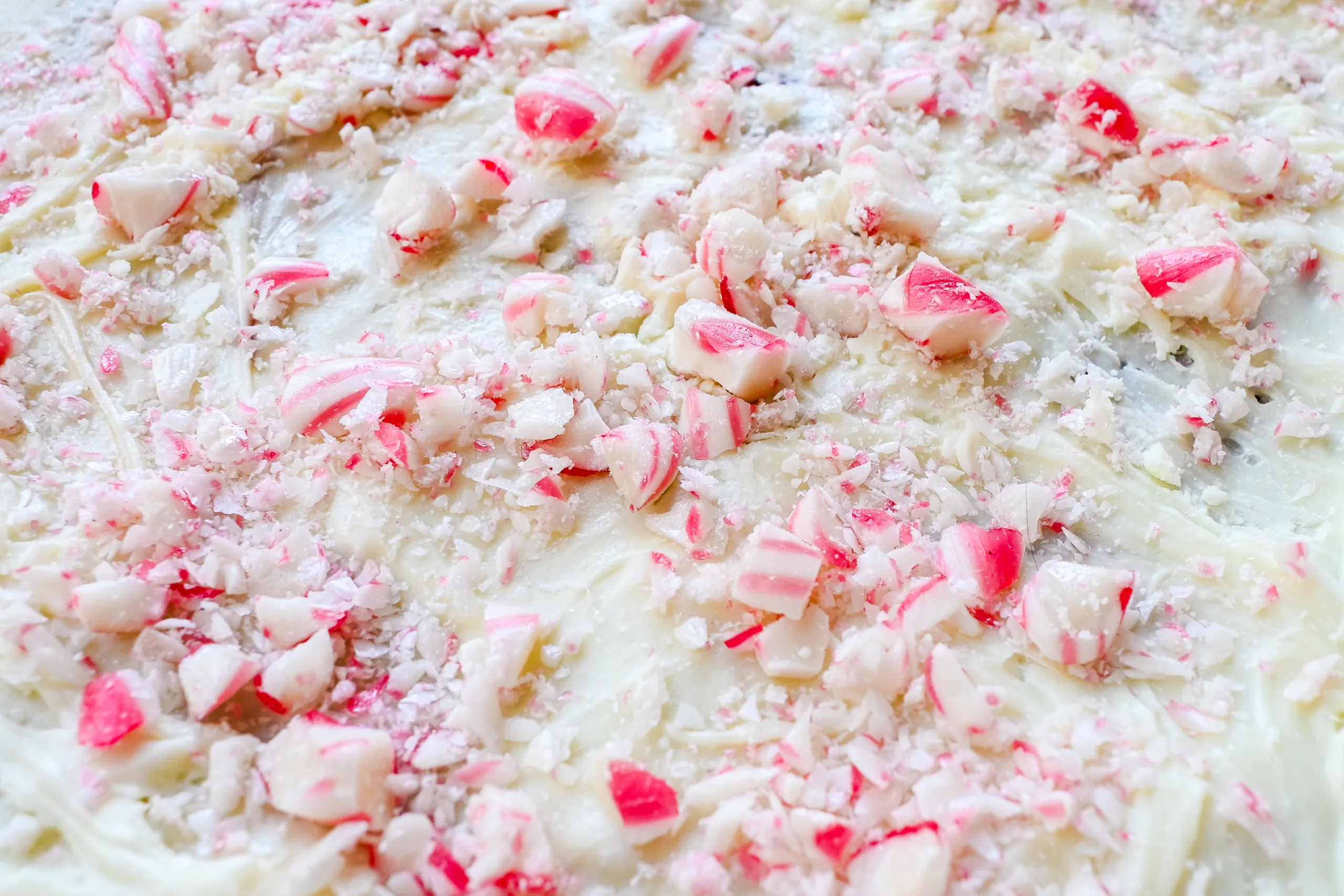 Close-up of crushed peppermint candy on the white chocolate layer of peppermint bark.