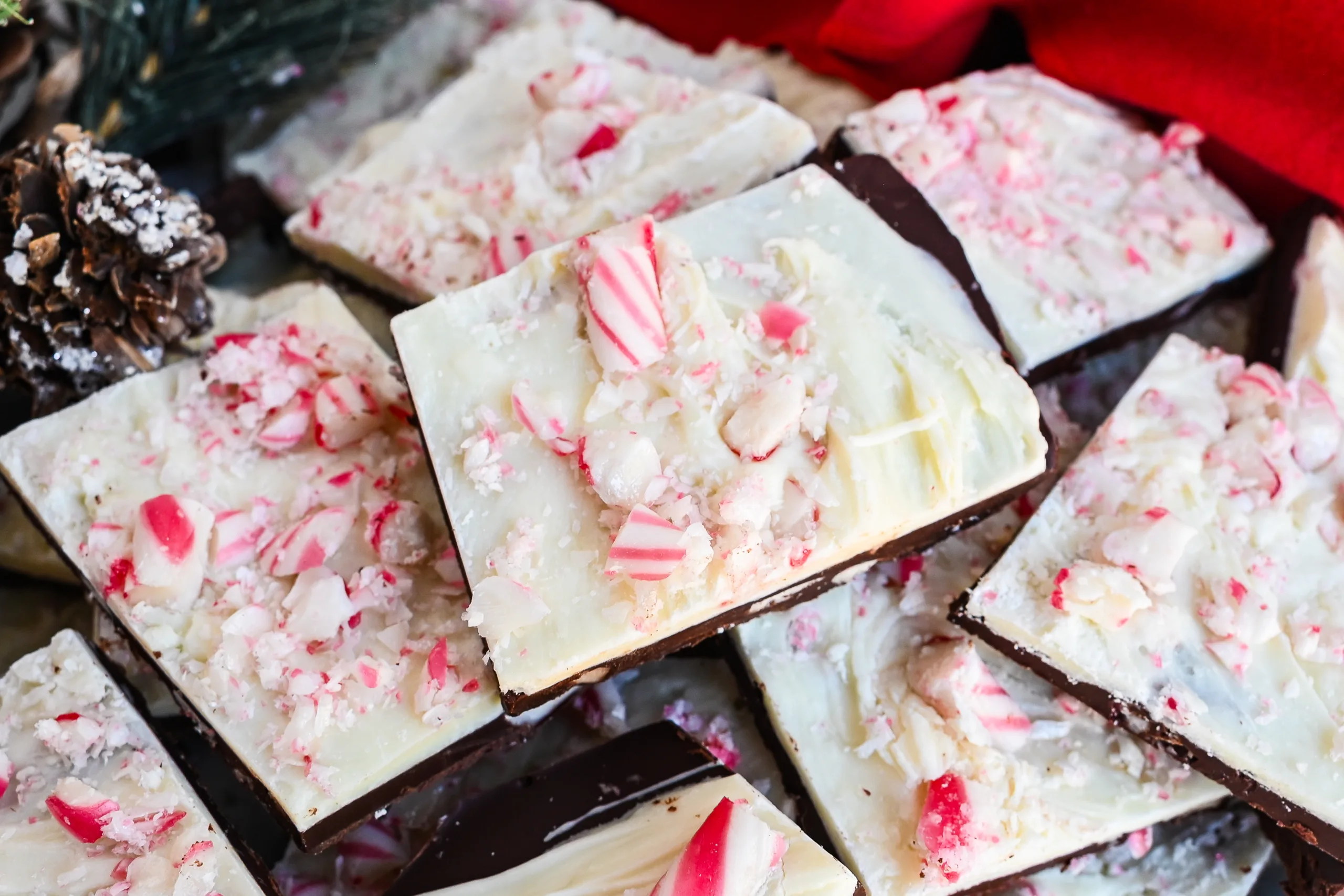 Close-up of layered peppermint bark pieces with white chocolate, dark chocolate, and crushed candy canes.