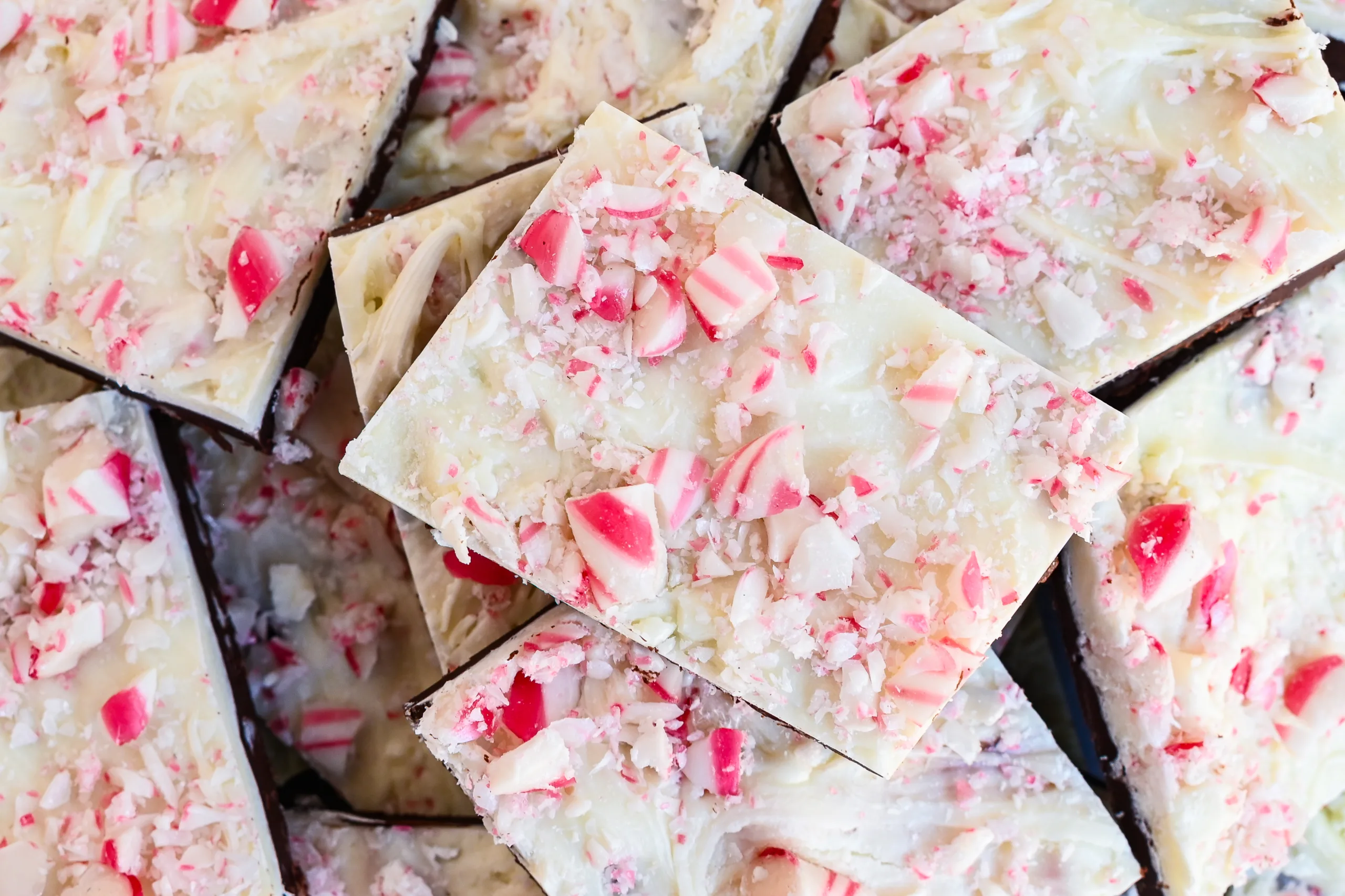 Finished peppermint bark pieces stacked with crushed peppermint candy on top.