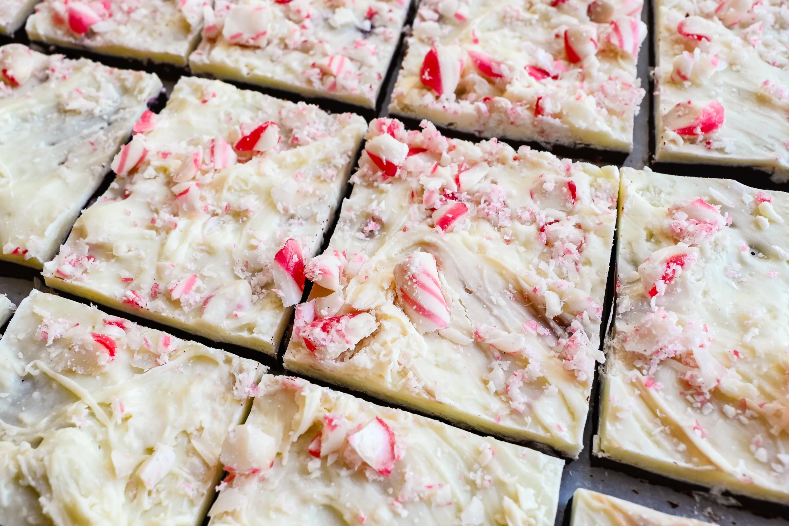 Peppermint bark cut into squares with white chocolate, dark chocolate, and crushed peppermint candy.