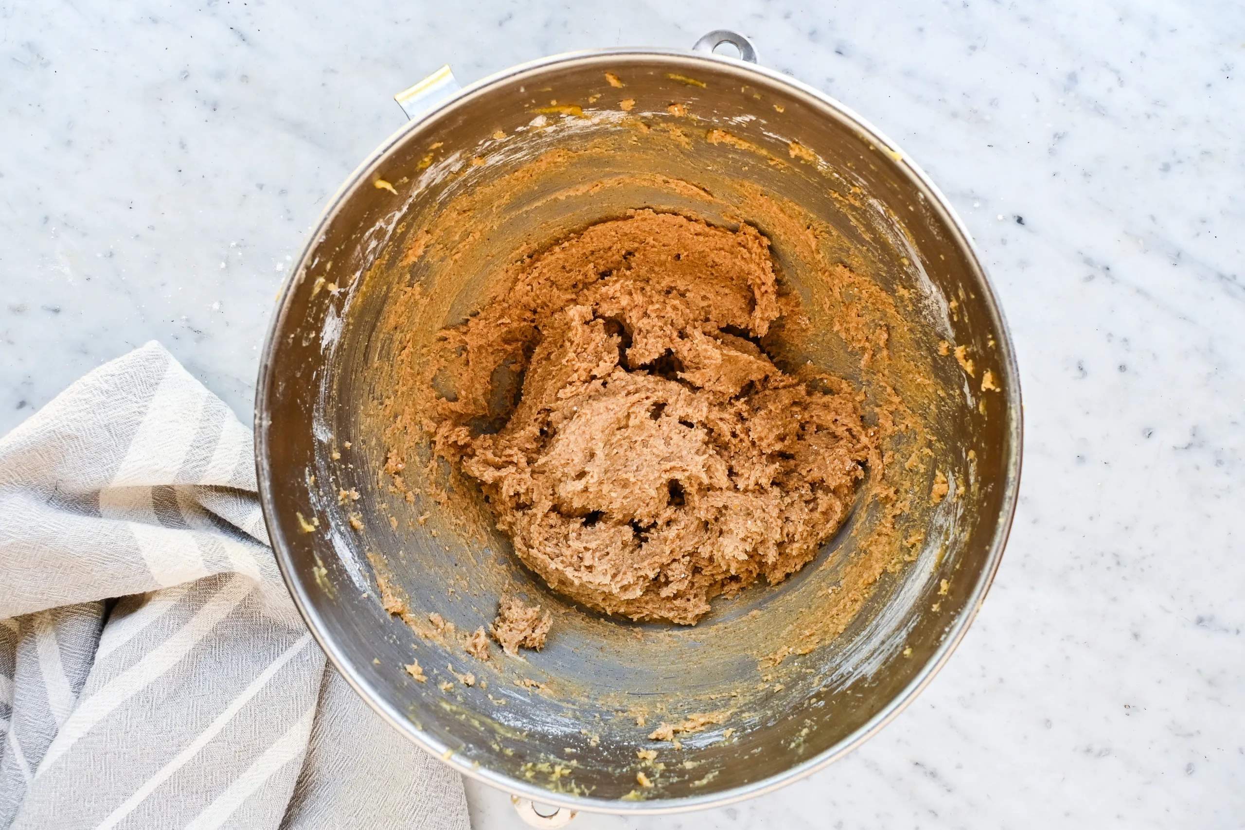Thick eggnog cookie dough mixed in a stand mixer bowl.