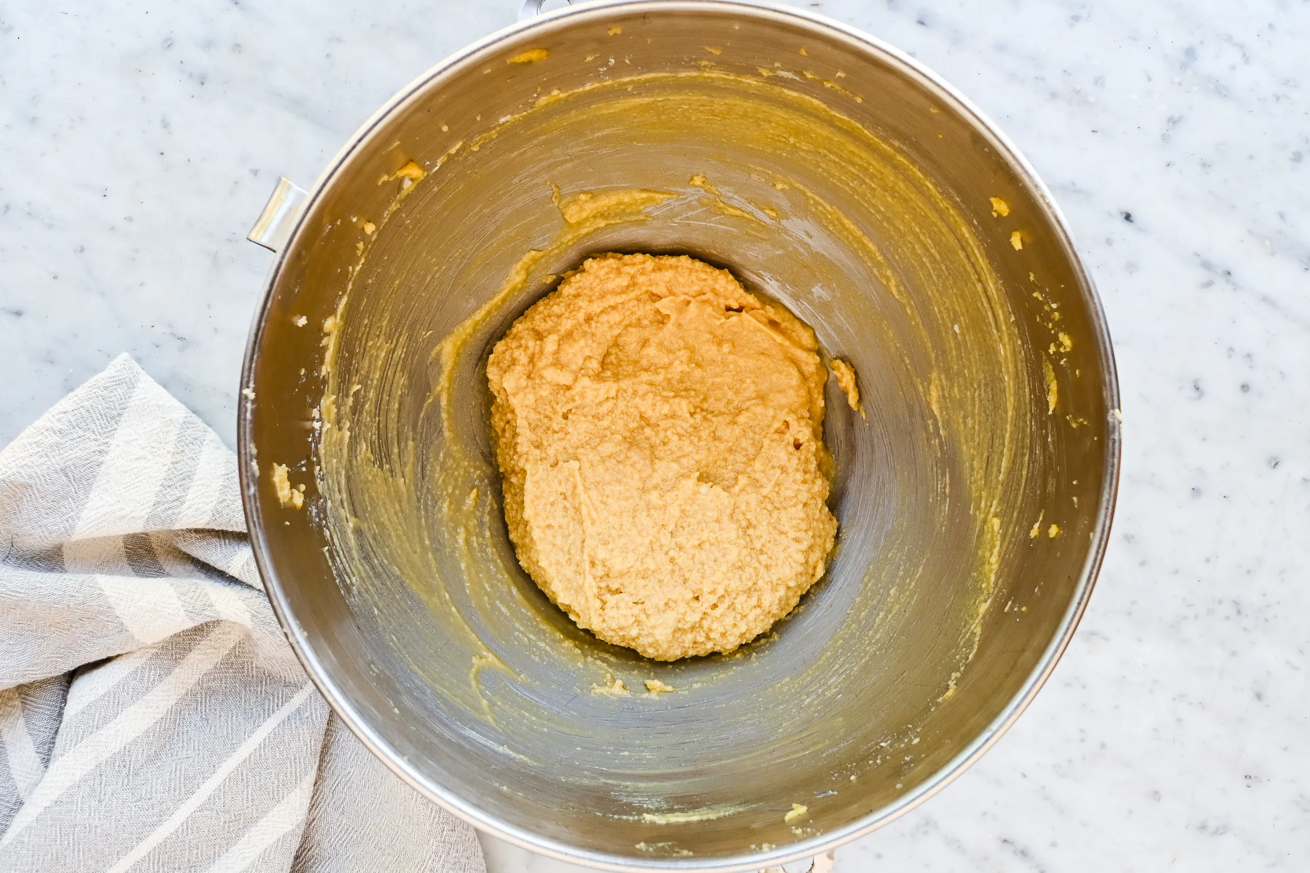 Wet ingredients creamed in a stand mixer bowl for eggnog cookies.
