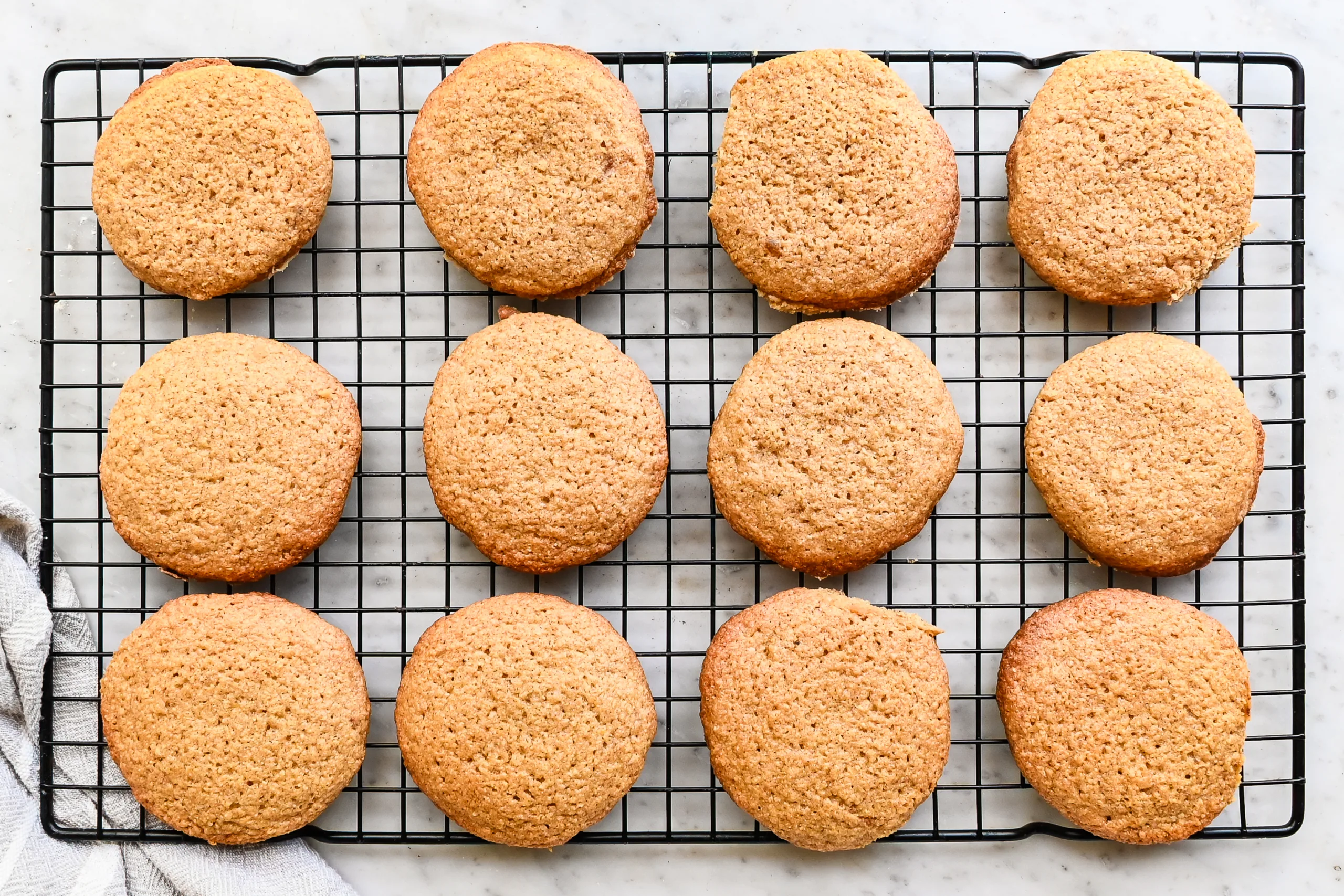 Plain eggnog cookies cooling on a wire rack before frosting.