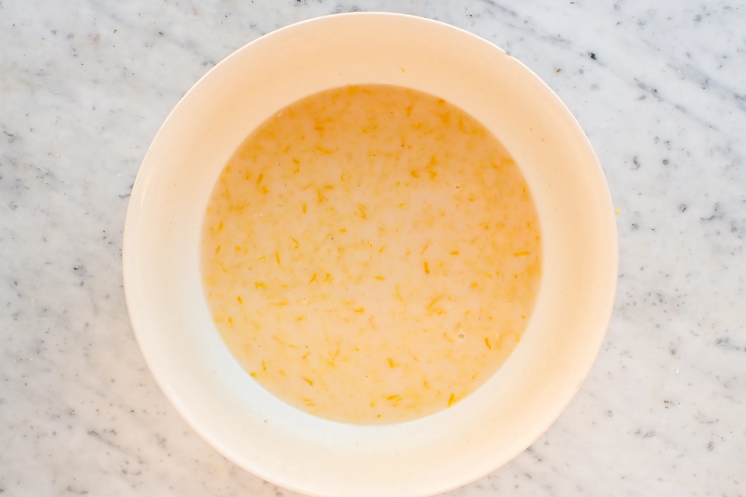 Lemon zest mixed into the liquid ingredients for lemon blueberry sourdough focaccia.