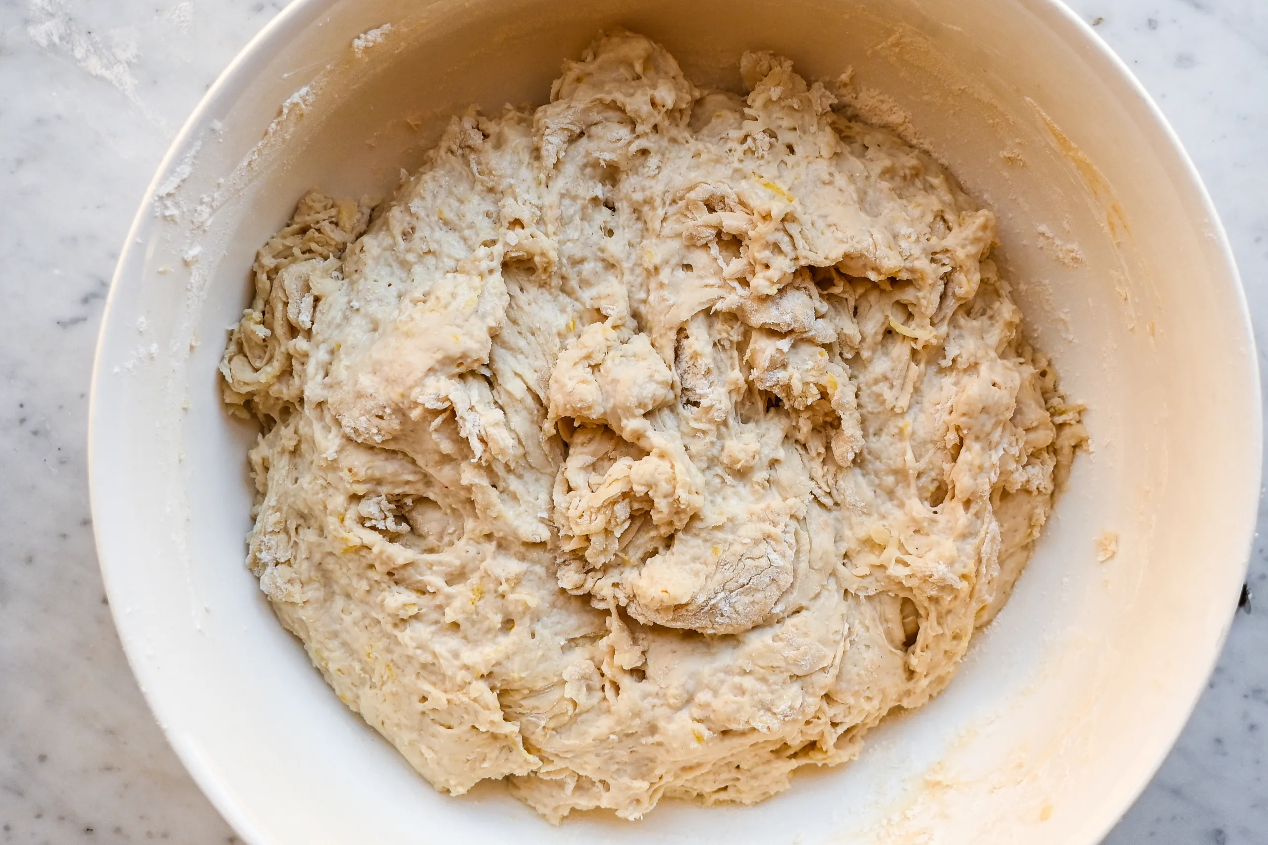 Sticky lemon sourdough focaccia dough mixed in a white bowl before the first rise.