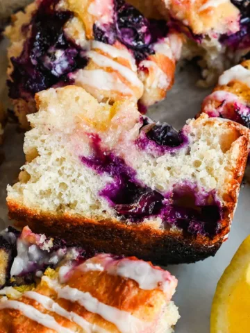 Sliced lemon blueberry sourdough focaccia showing the soft airy crumb, juicy blueberries, golden crust, and lemon glaze.