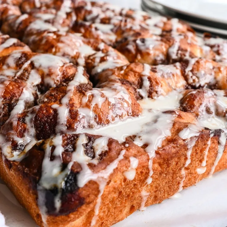Sourdough discard cinnamon roll focaccia with cinnamon sugar pockets and vanilla glaze on top.
