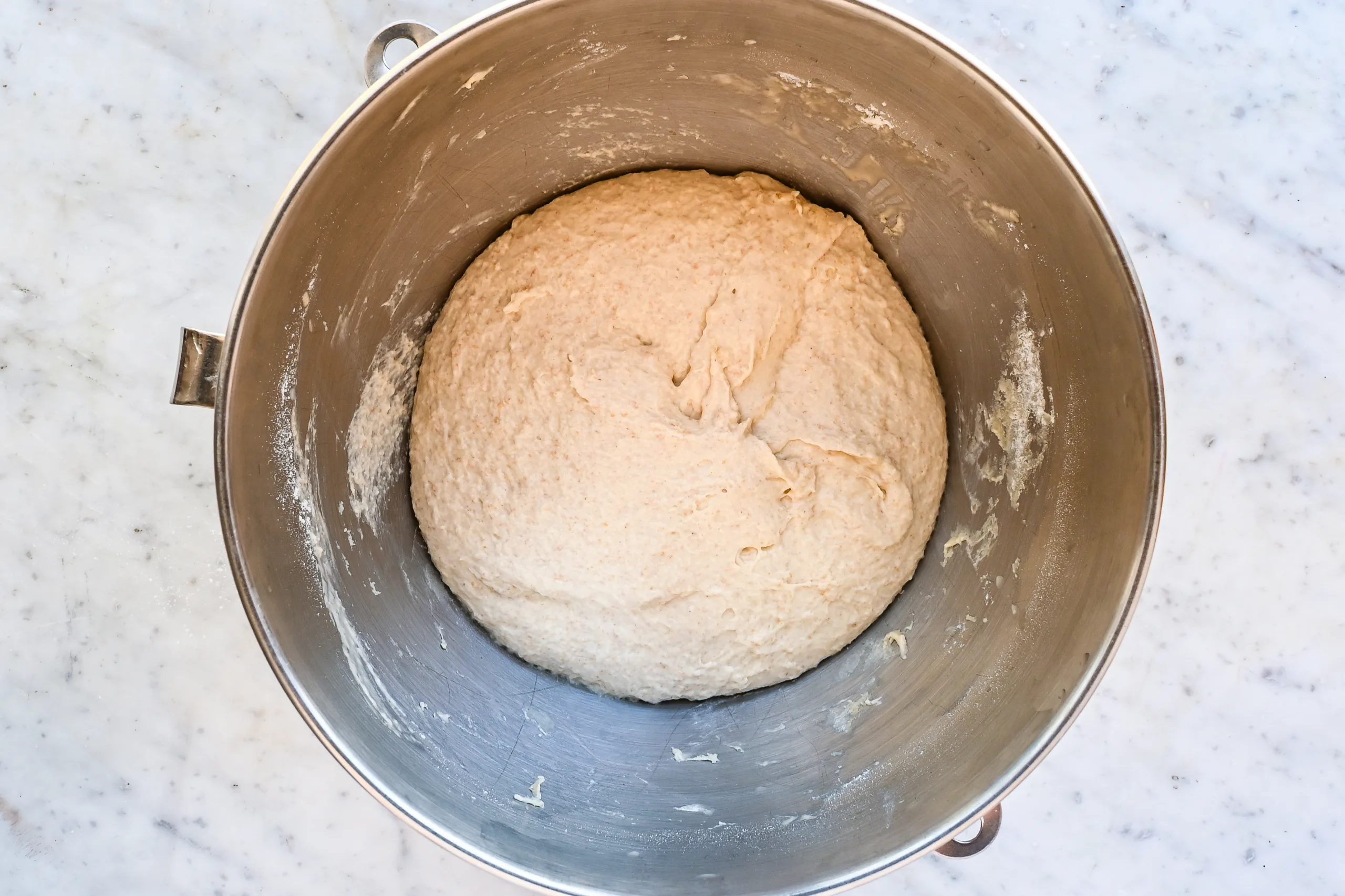 Soft sourdough focaccia dough mixed in a stand mixer bowl.